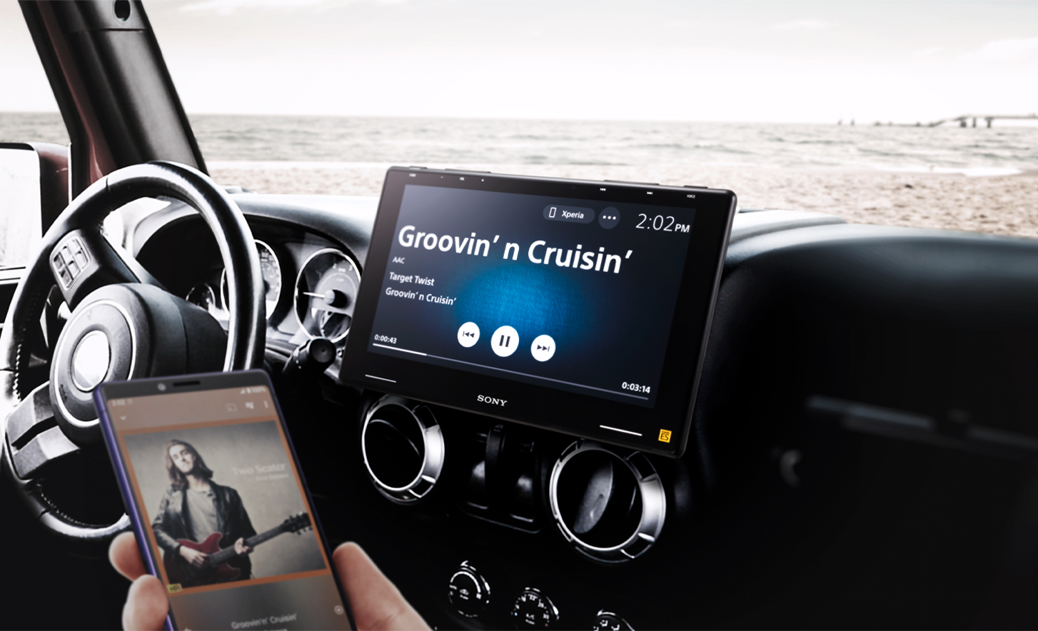 Zdjęcie radia samochodowego XAV-9550ES w desce rozdzielczej i osoby przesyłającej do niego muzykę z telefonu